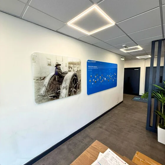 Phase 2 before photo of where 3D foamex logo and text vinyl will be installed. Graphic of Frank Donaldson and a sign of Donaldson company history currently in place, set to be moved.